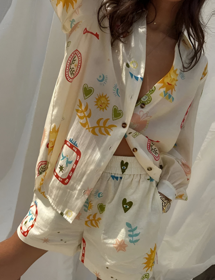 Camicia e pantaloncini in seta con stampa colorata di cuori, sole e foglie. Moda estiva donna, abbigliamento casual elegante.