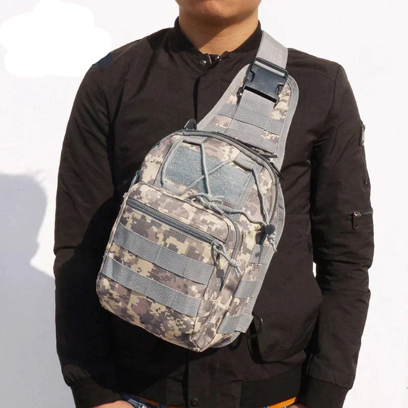 Zaino a tracolla mimetico militare indossato da uomo, ideale per escursioni e attività all'aperto. Design compatto e resistente, con tasche multiple.