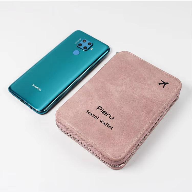 Smartphone Huawei blu accanto a portafoglio da viaggio Pieru rosa, design elegante, accessori moda, tecnologia e praticità per viaggiatori.