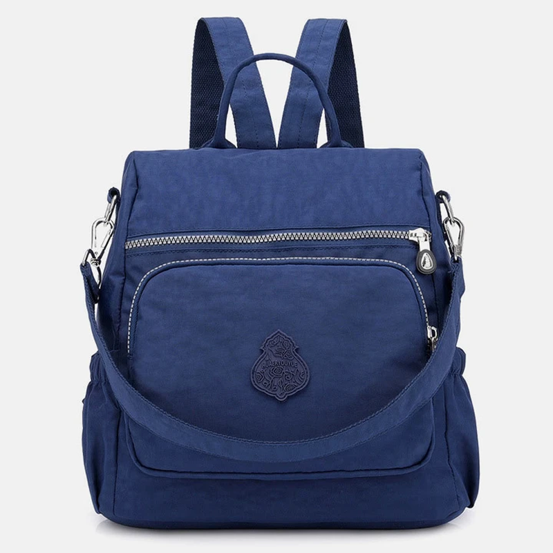 Zaino blu in nylon impermeabile con tasca frontale con zip, spallacci regolabili e manico superiore. Design elegante e pratico per viaggi e scuola.