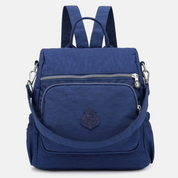 Zaino blu in nylon impermeabile con tasca frontale con zip, spallacci regolabili e manico superiore. Design elegante e pratico per viaggi e scuola.