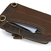 Borsa a tracolla in pelle marrone con cerniera aperta, anelli metallici dorati e tasca interna visibile. Design elegante e funzionale per uomo.
