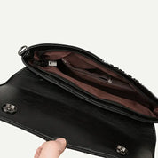 Borsa a tracolla in pelle nera aperta, interno foderato marrone con tasche multiple e chiusura a bottone magnetico. Accessorio moda elegante e pratico.
