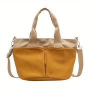 Borsa a tracolla in tela gialla con manici beige, tasche frontali e tracolla regolabile. Design casual, ideale per uso quotidiano.