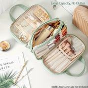 Borsa da trucco verde con scomparti trasparenti, contenente pennelli, rossetti e gioielli. Ideale per organizzare cosmetici e accessori.