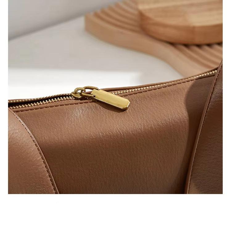 Borsa in pelle marrone con cerniera dorata, design elegante e moderno, accessorio moda donna, ideale per look casual e formali.