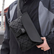 Borsa a tracolla nera con design geometrico, indossata da una persona in giacca sportiva. Accessorio moda unisex, stile urbano e moderno.