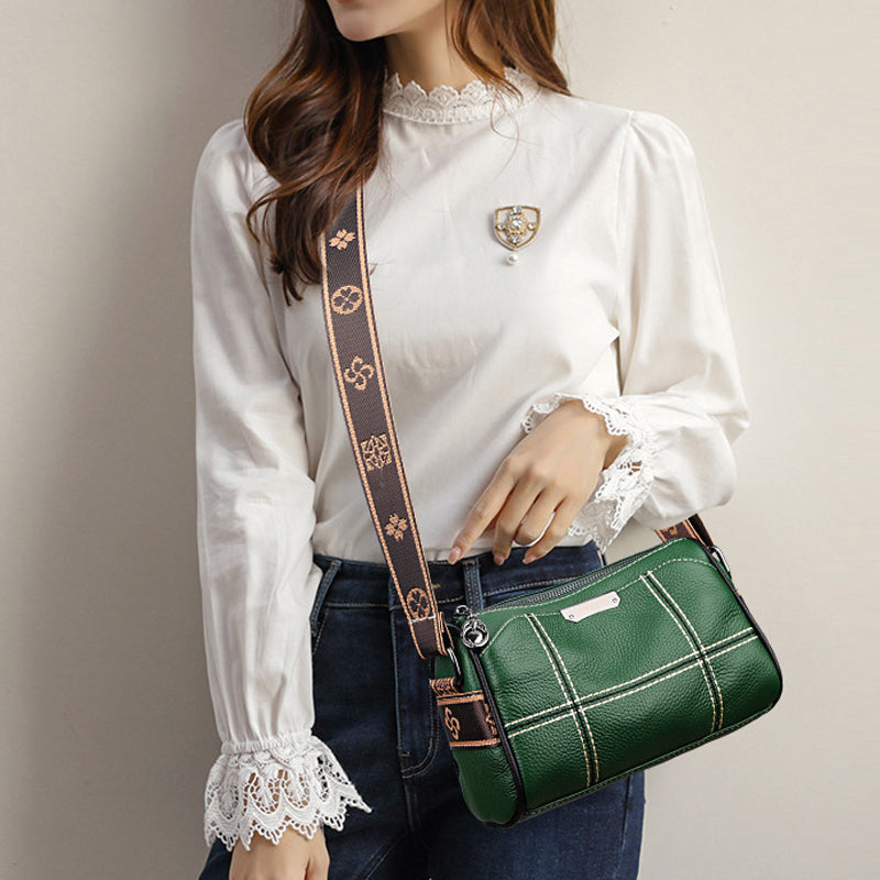 Donna con borsa a tracolla verde in pelle, decorata con motivo a quadri bianchi, indossa camicia bianca elegante con pizzo. Accessorio moda femminile.