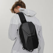 Zaino monospalla nero moderno su uomo con giacca grigia, design geometrico, ideale per viaggi e uso urbano. Accessorio moda funzionale e stiloso.
