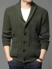 Cardigan uomo verde oliva con bottoni grandi, collo sciallato, tasche frontali, indossato su maglietta bianca. Stile casual elegante.