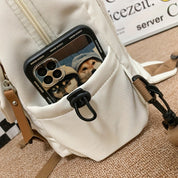 Zaino bianco con tasca frontale contenente un iPhone con custodia raffigurante due cani. Accessori moda, tecnologia, cover smartphone.