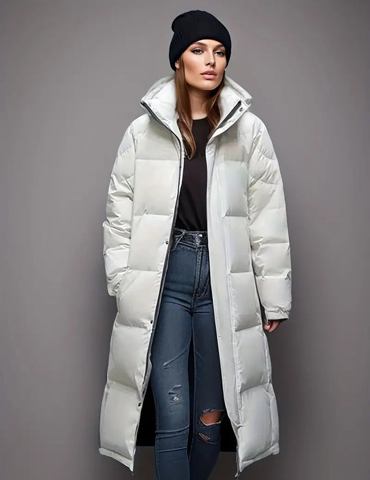 Donna con cappotto lungo imbottito bianco, jeans strappati e berretto nero. Moda invernale, abbigliamento casual elegante.
