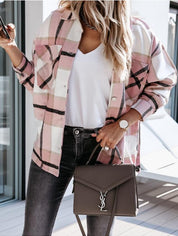 Donna con camicia a quadri rosa, t-shirt bianca, jeans neri e borsa a tracolla marrone con logo. Look casual chic, moda autunnale.