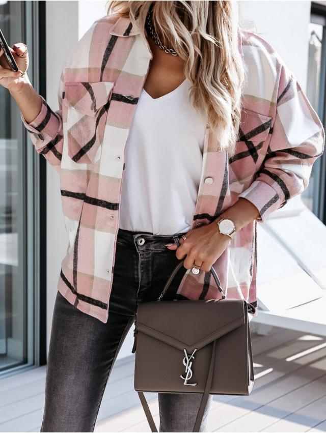 Donna con camicia a quadri rosa, t-shirt bianca, jeans neri e borsa a tracolla marrone con logo. Look casual chic, moda autunnale.