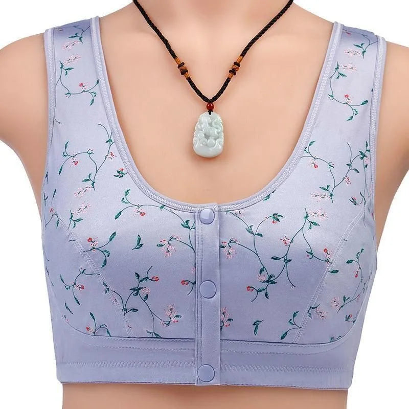 Reggiseno sportivo viola con stampa floreale, chiusura frontale a bottoni, indossato con collana pendente. Intimo donna comodo e alla moda.