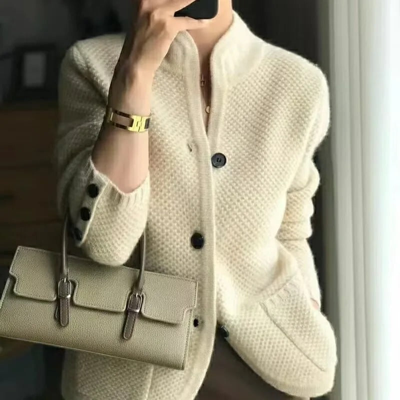 Giacca donna in lana beige con bottoni neri, abbinata a borsa a mano beige. Moda autunnale elegante, stile casual chic.