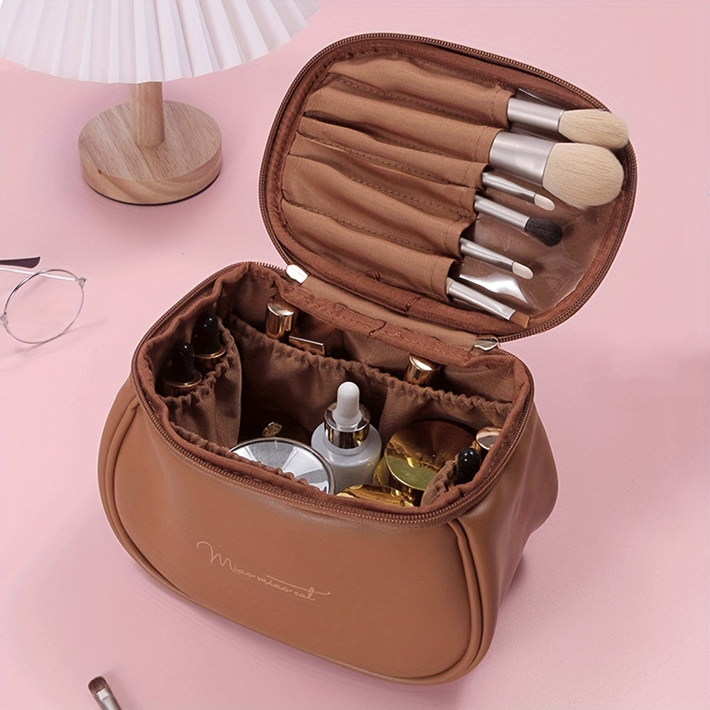 Borsa trucco marrone aperta su tavolo rosa, con pennelli e cosmetici. Elegante organizer da viaggio per make-up. Accessori bellezza essenziali.