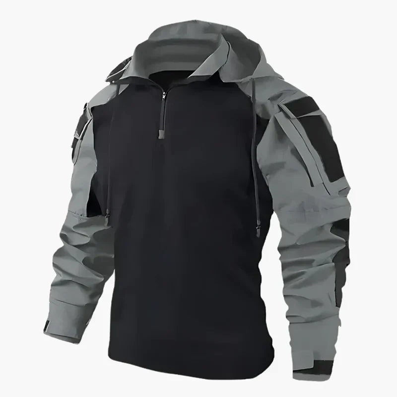 Giacca softshell nera e grigia con cappuccio, zip frontale e tasche multiple. Abbigliamento outdoor impermeabile e antivento per escursionismo.
