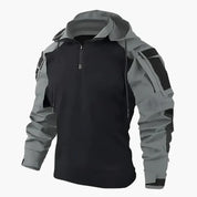 Giacca softshell nera e grigia con cappuccio, zip frontale e tasche multiple. Abbigliamento outdoor impermeabile e antivento per escursionismo.