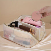 Beauty case trasparente con cerniera, contenente trucchi e cosmetici vari. Ideale per organizzare il make-up. Accessorio da viaggio essenziale.