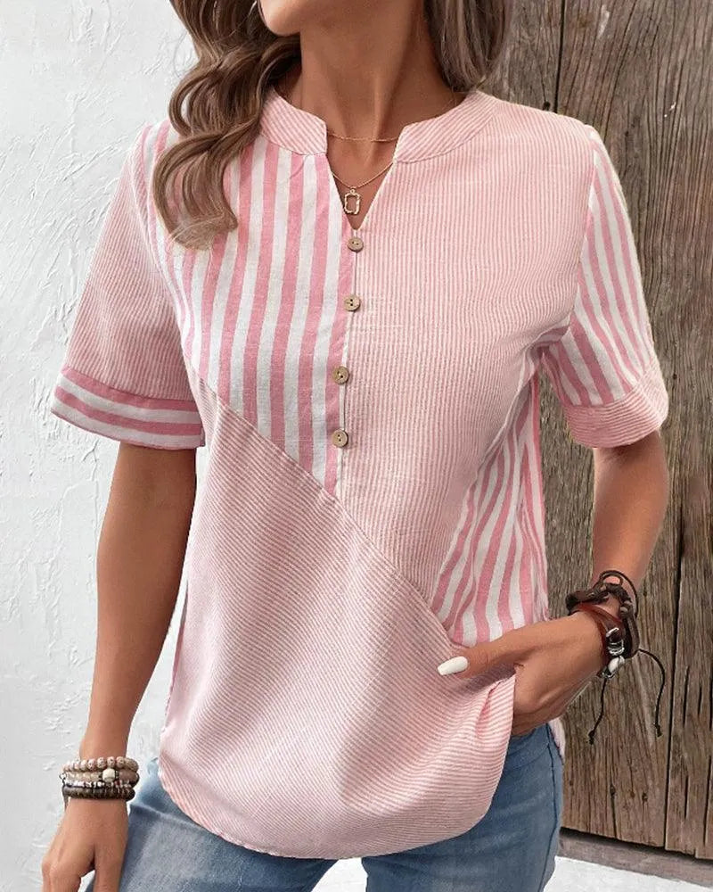 Blusa donna a righe rosa e bianche, maniche corte, scollo a V con bottoni, stile casual estivo, tessuto leggero, abbinata a jeans.