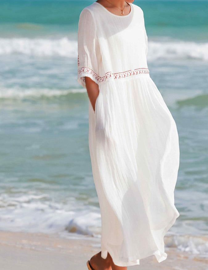 Abito lungo bianco estivo da donna, maniche corte, tessuto leggero, ideale per la spiaggia. Stile casual elegante, perfetto per vacanze al mare.