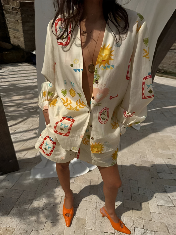 Donna con camicia oversize stampata con motivi colorati e scarpe arancioni su pavimento in pietra. Moda estiva, abbigliamento casual chic.