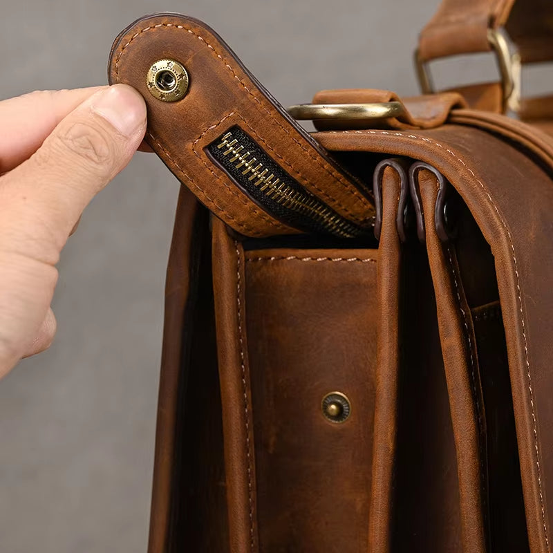 Borsa in pelle marrone con chiusura a bottone e cerniera, design elegante e resistente, ideale per lavoro e viaggio. Accessorio moda uomo.