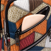 Zaino in pelle patchwork multicolore con tasca aperta, cerniere nere e design geometrico. Accessorio moda unico e trendy.