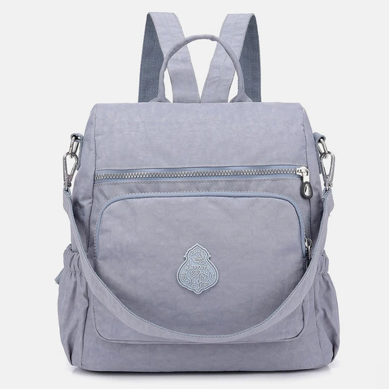 Zaino grigio chiaro in tessuto resistente, con tasca frontale con cerniera e spallacci regolabili. Design elegante e pratico per uso quotidiano.