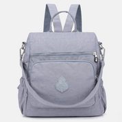 Zaino grigio chiaro in tessuto resistente, con tasca frontale con cerniera e spallacci regolabili. Design elegante e pratico per uso quotidiano.