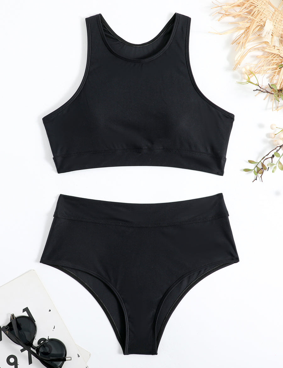 Costume da bagno nero a due pezzi, top sportivo e slip a vita alta, su sfondo bianco con occhiali da sole e decorazioni floreali.