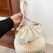 Borsa a spalla bianca in pelle, design elegante con manico regolabile, su sfondo neutro. Accessorio moda donna, stile contemporaneo.