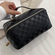 Borsa cosmetica nera a scacchi con cerniera dorata, design elegante e manico superiore, ideale per viaggi e organizzazione trucco.