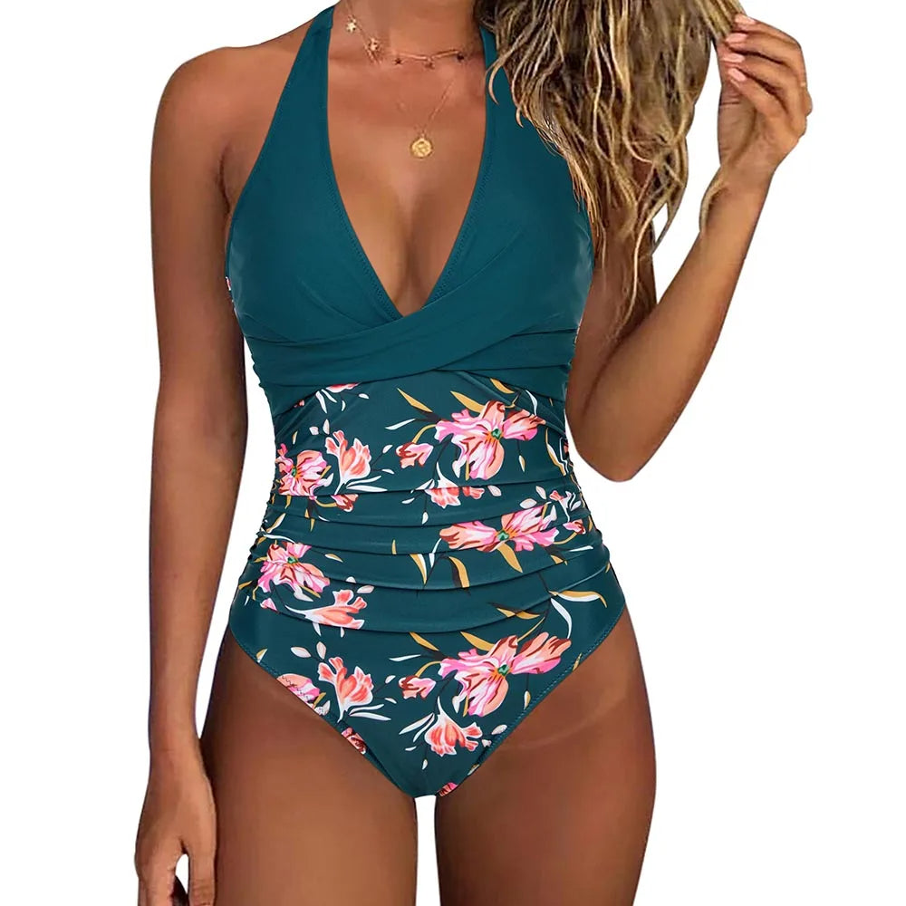 Costume intero donna verde con stampa floreale rosa, scollo a V e spalline incrociate. Elegante e alla moda per l'estate.