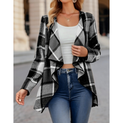 Giacca a quadri bianco e nero da donna, stile casual, indossata con top bianco e jeans. Moda autunnale, abbigliamento urbano elegante.