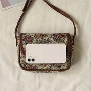 Borsa a tracolla vintage in tessuto floreale con smartphone bianco, design elegante, accessorio moda donna, perfetta per look casual e chic.