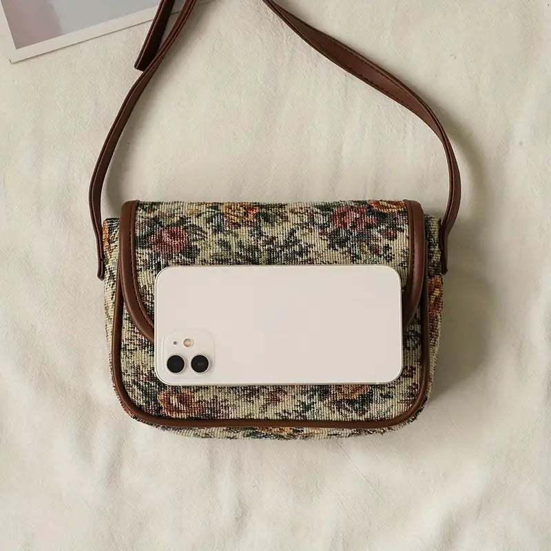 Borsa a tracolla vintage in tessuto floreale con smartphone bianco, design elegante, accessorio moda donna, perfetta per look casual e chic.