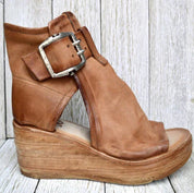 Sandalo donna in pelle marrone con zeppa in legno, fibbia metallica grande, design aperto. Scarpe estive eleganti, moda casual.