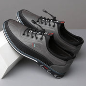 Scarpe da uomo casual grigie, design moderno, suola antiscivolo, lacci neri, dettagli tricolore, ideali per look urbano e comfort quotidiano.