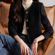 Giacca donna elegante nera in tweed, abbinata a maglia bianca e jeans, stile casual chic, perfetta per moda autunno inverno.