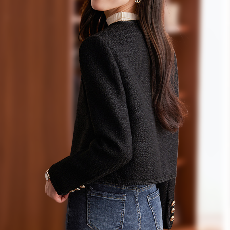 Giacca donna elegante in tweed nero, design moderno, bottoni dorati, abbinata a jeans casual. Moda autunno-inverno, stile chic e sofisticato.