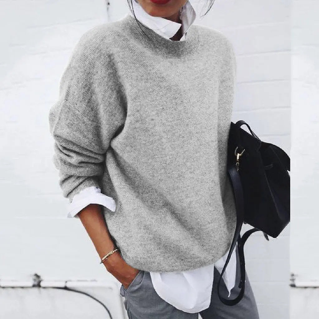 Maglione grigio donna in lana, stile casual, abbinato a camicia bianca e borsa nera. Look autunnale elegante e confortevole.