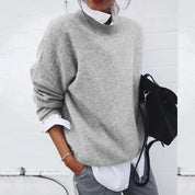 Maglione grigio donna in lana, stile casual, abbinato a camicia bianca e borsa nera. Look autunnale elegante e confortevole.