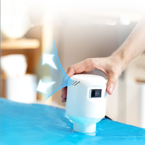 Dispositivo sigillatore sottovuoto portatile bianco, con interruttore, utilizzato su sacchetto blu per conservazione alimenti. Innovativo e compatto.