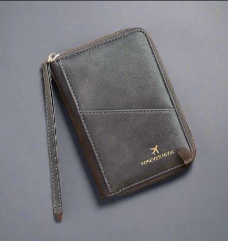 Portafoglio da viaggio in pelle nera con cerniera, logo dorato "FOREVER MYWAY", cinturino da polso, design elegante e funzionale per documenti.