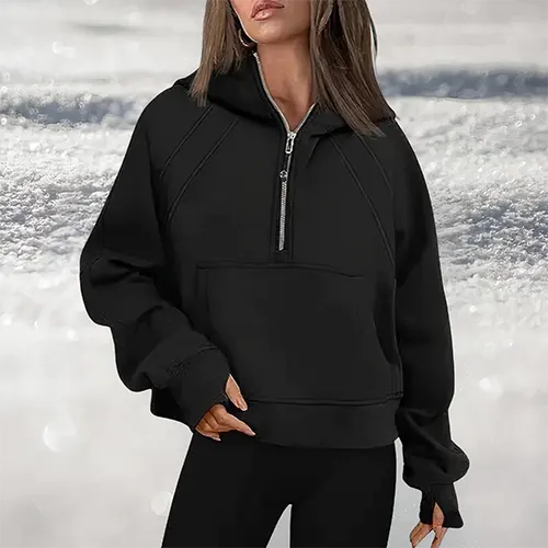 Donna con felpa nera oversize con cappuccio e zip, sfondo sfocato. Moda casual donna, abbigliamento autunnale, stile urbano.