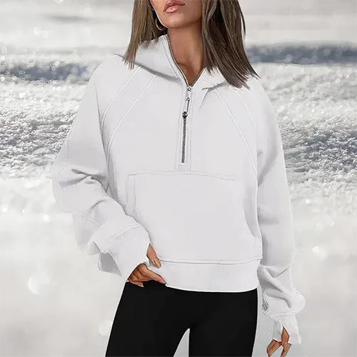 Felpa bianca con cappuccio e zip, indossata da una donna su sfondo innevato. Moda invernale, abbigliamento casual, stile confortevole.