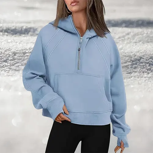 Felpa donna azzurra con cappuccio e zip, tasca frontale, indossata su sfondo innevato. Abbigliamento casual invernale, moda femminile.