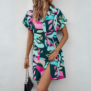 Abito chemisier donna a maniche corte, fantasia astratta multicolore verde, rosa e blu. Perfetto per moda estiva casual.